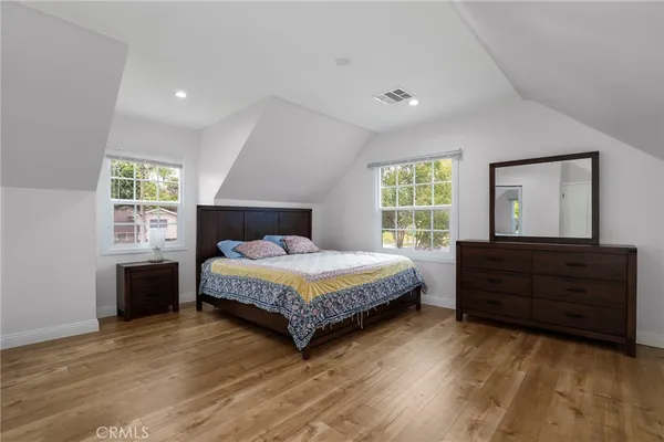 a bedroom with a bed and a dresser next to a window