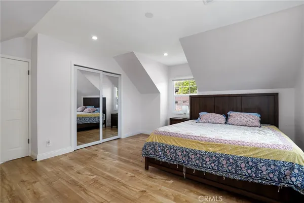 a bedroom with a bed and a refrigerator