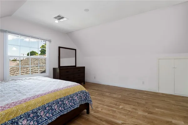 a bedroom with a large bed and a flat tv screen on dresser
