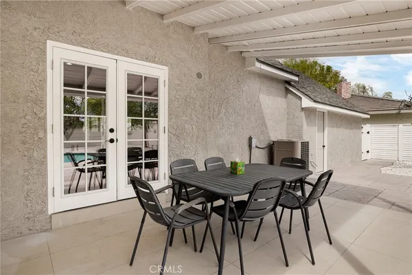 a view of a patio with a table and chairs and potted plants
