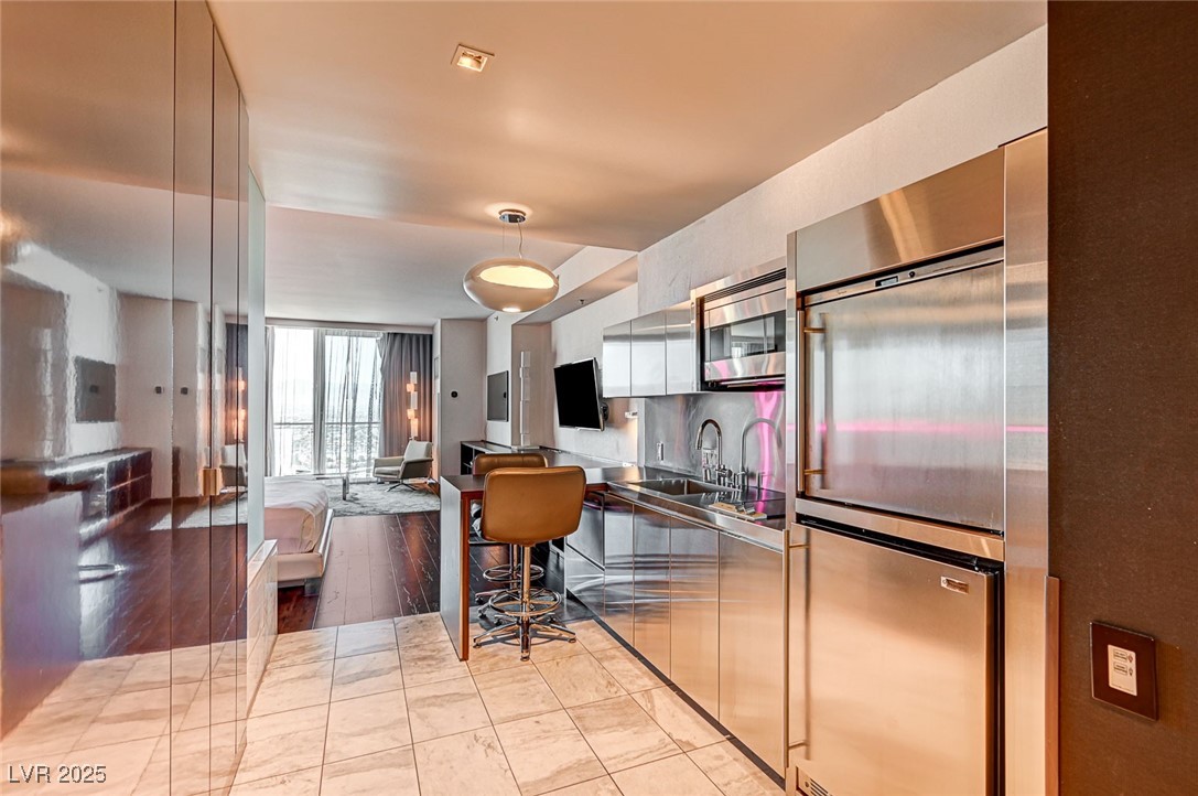 4381 West Flamingo Road, Unit 53307 Las Vegas, NV 89103 - Photo 45 of 45 Kitchen with stainless steel appliances, pendant lighting, floor to ceiling windows, open floor plan, and modern cabinets