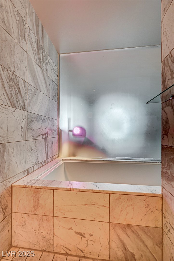 4381 West Flamingo Road, Unit 53307 Las Vegas, NV 89103 - Photo 15 of 45 Bathroom featuring tile walls and tiled shower