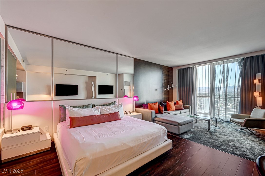 4381 West Flamingo Road, Unit 53307 Las Vegas, NV 89103 - Photo 2 of 45 Bedroom with dark wood finished floors and a wall of windows