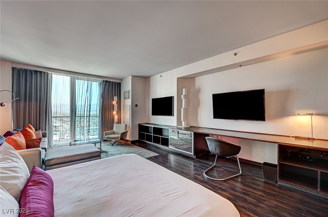 4381 West Flamingo Road, Unit 53307 Las Vegas, NV 89103 - Photo 3 of 45 Bedroom featuring dark wood-type flooring and expansive windows