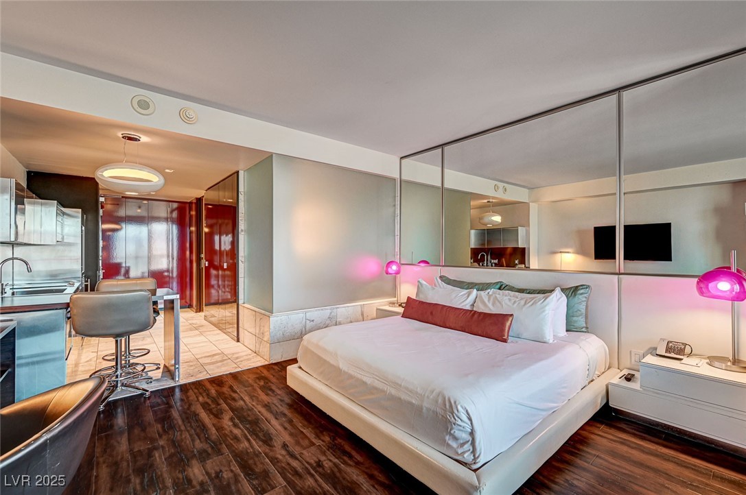 4381 West Flamingo Road, Unit 53307 Las Vegas, NV 89103 - Photo 5 of 45 Bedroom with wood finished floors and a wainscoted wall