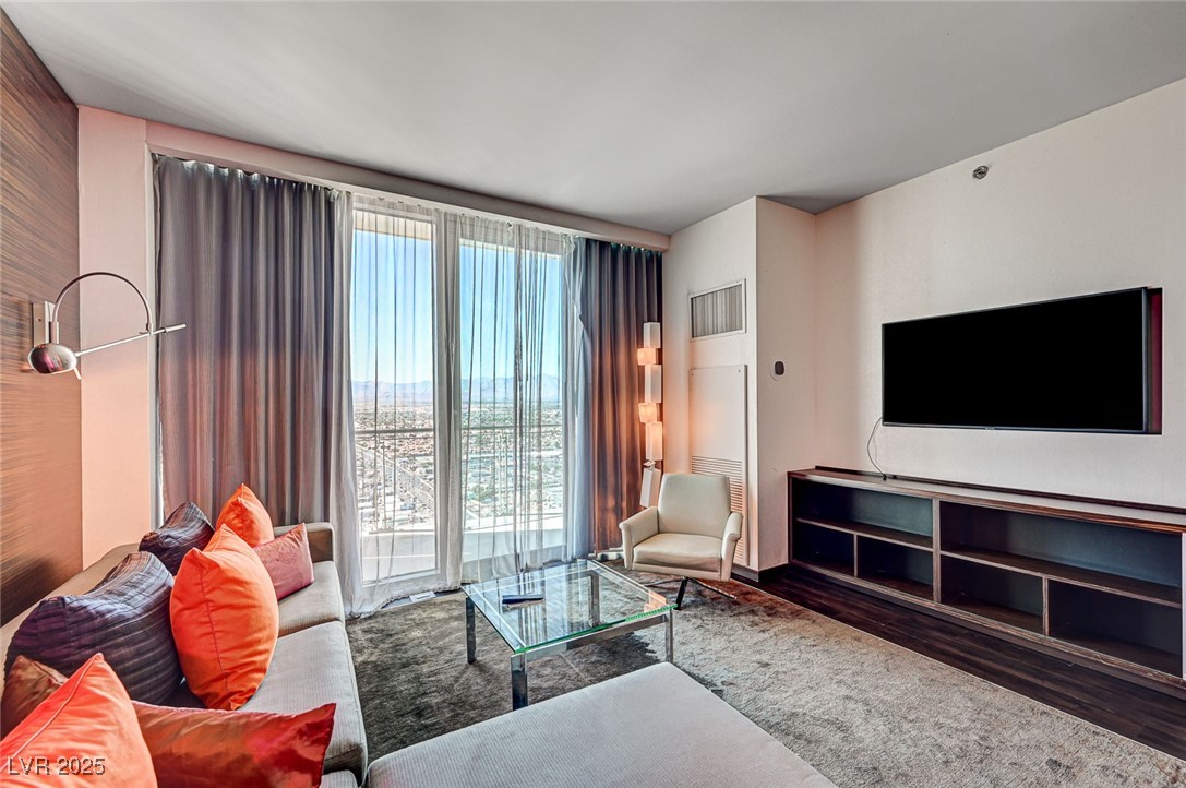 4381 West Flamingo Road, Unit 53307 Las Vegas, NV 89103 - Photo 6 of 45 Living room with dark wood-type flooring and expansive windows