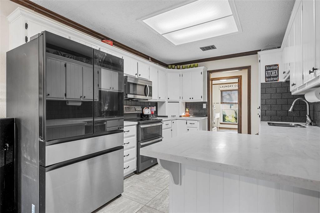 361 Vandiver Road Moody, TX 76557 - Photo 11 of 33 a kitchen with granite countertop a refrigerator stove top oven and sink
