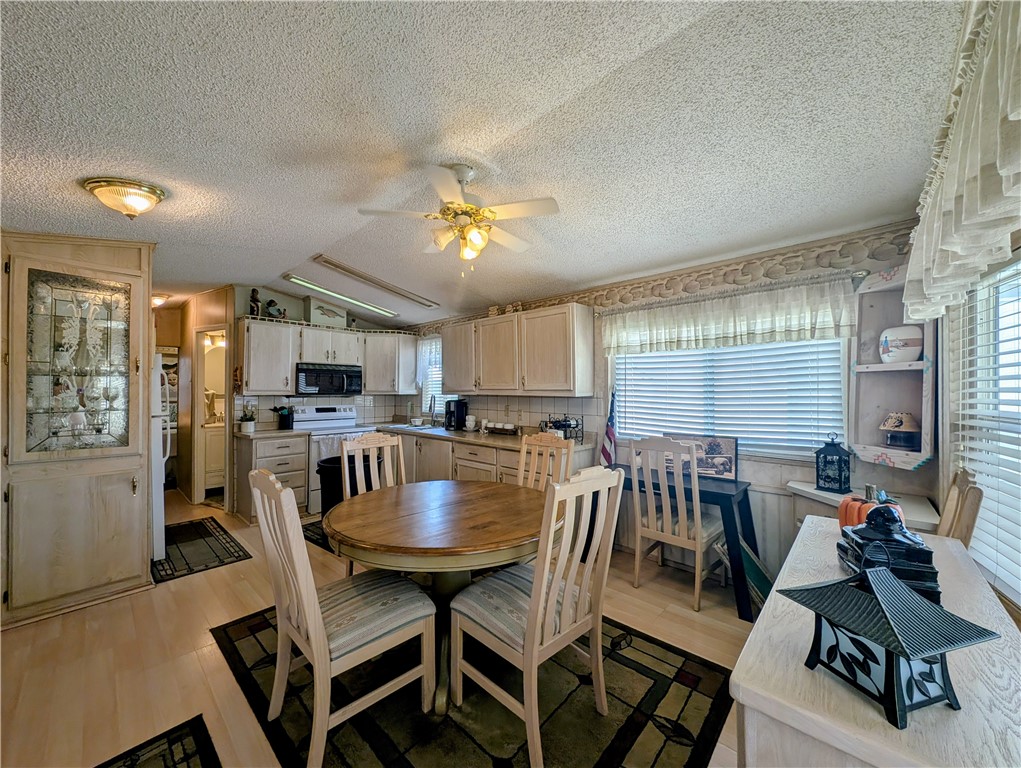 2000 Ramar Road, Unit 528 Bullhead City, AZ 86442 - Photo 19 of 30 The kitchen features light-colored cabinetry, a ceiling fan, and an integrated dining area with a round table and seating