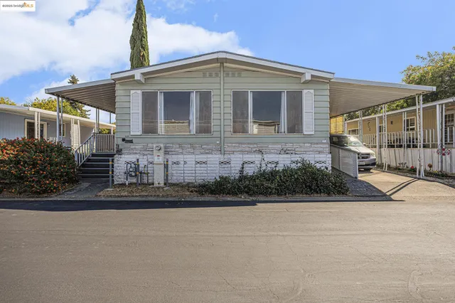 a view of a house with a big yard plants and palm trees