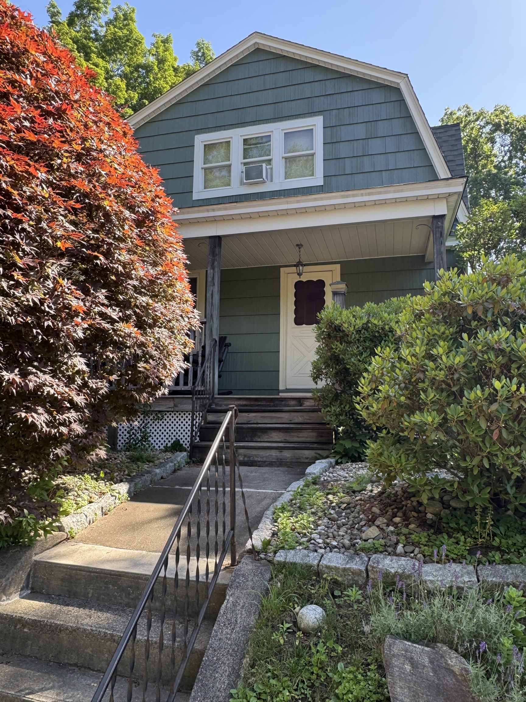 a front view of house with deck and yard