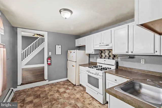 a kitchen with white cabinets and white appliances