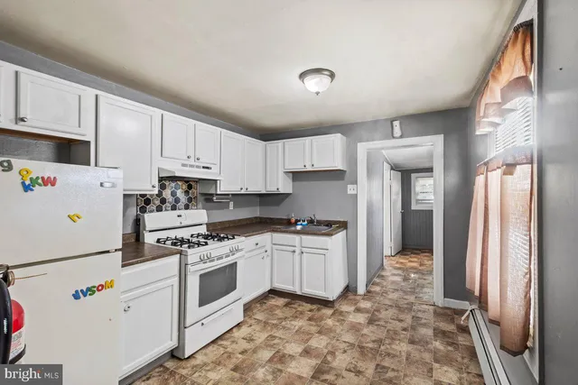 a kitchen with white cabinets and white appliances