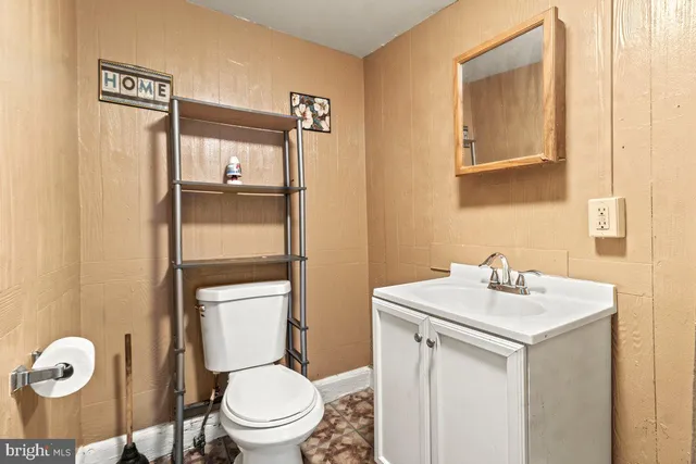 a bathroom with a toilet sink and mirror
