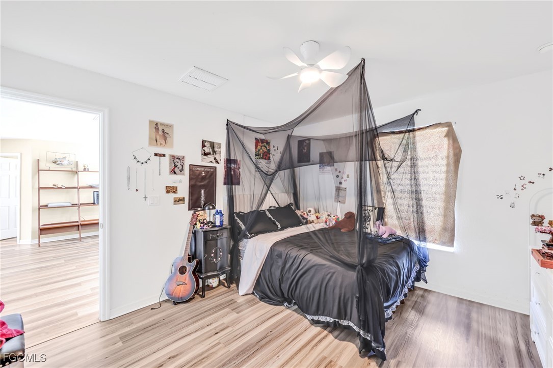 14067 Danpark Loop Fort Myers, FL 33912 - Photo 20 of 41 a bedroom with a bed and a wooden floor