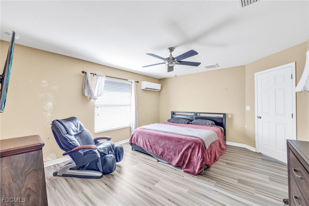 14067 Danpark Loop Fort Myers, FL 33912 - Photo 24 of 41 a bedroom with a bed and wooden floor