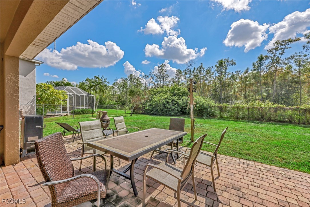 14067 Danpark Loop Fort Myers, FL 33912 - Photo 29 of 41 a view of a patio with a table chairs and a garden