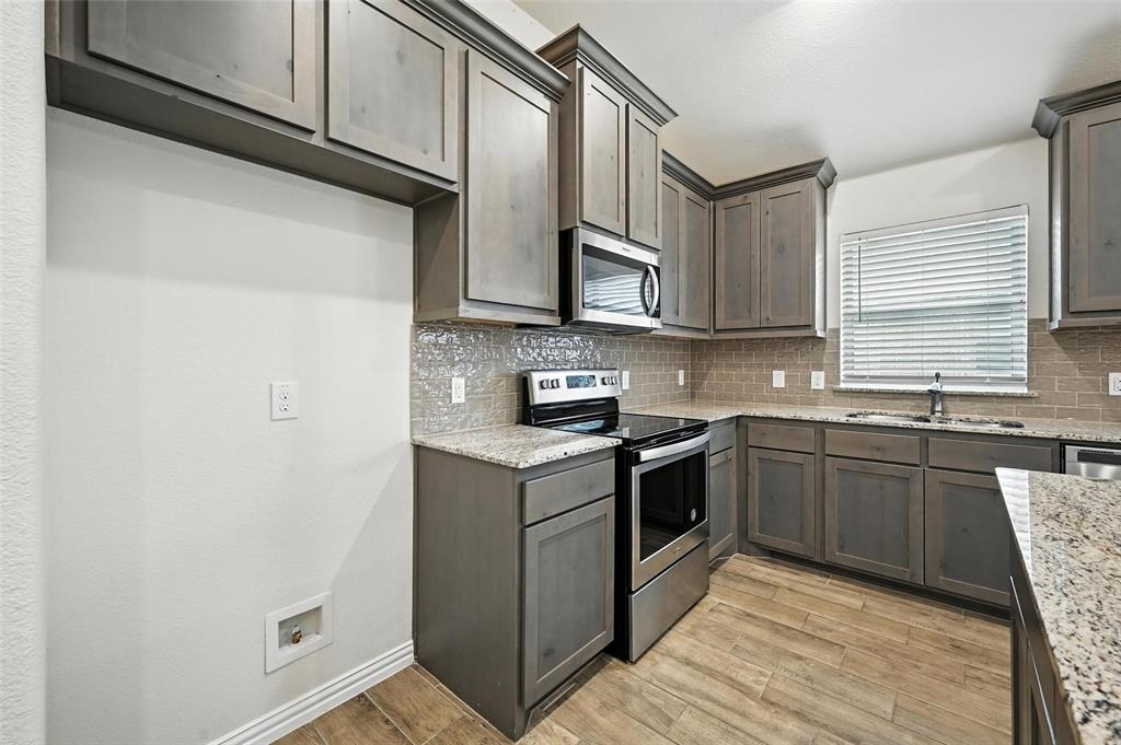 5 Pheasant Run Sanger, TX 76266 - Photo 6 of 27 Kitchen featuring stainless steel appliances, backsplash, and light wood-style flooring
