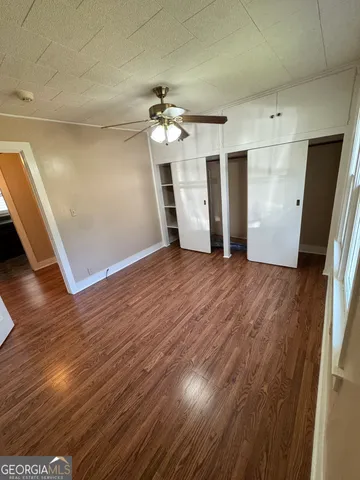 a view of a livingroom with wooden floor and a ceiling fan