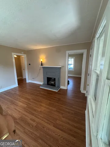 a view of empty room with wooden floor and fireplace