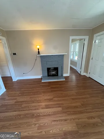 a view of a livingroom with wooden floor and a fireplace
