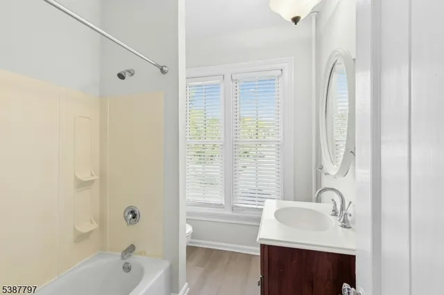 a view of a livingroom with a chandelier fan and windows