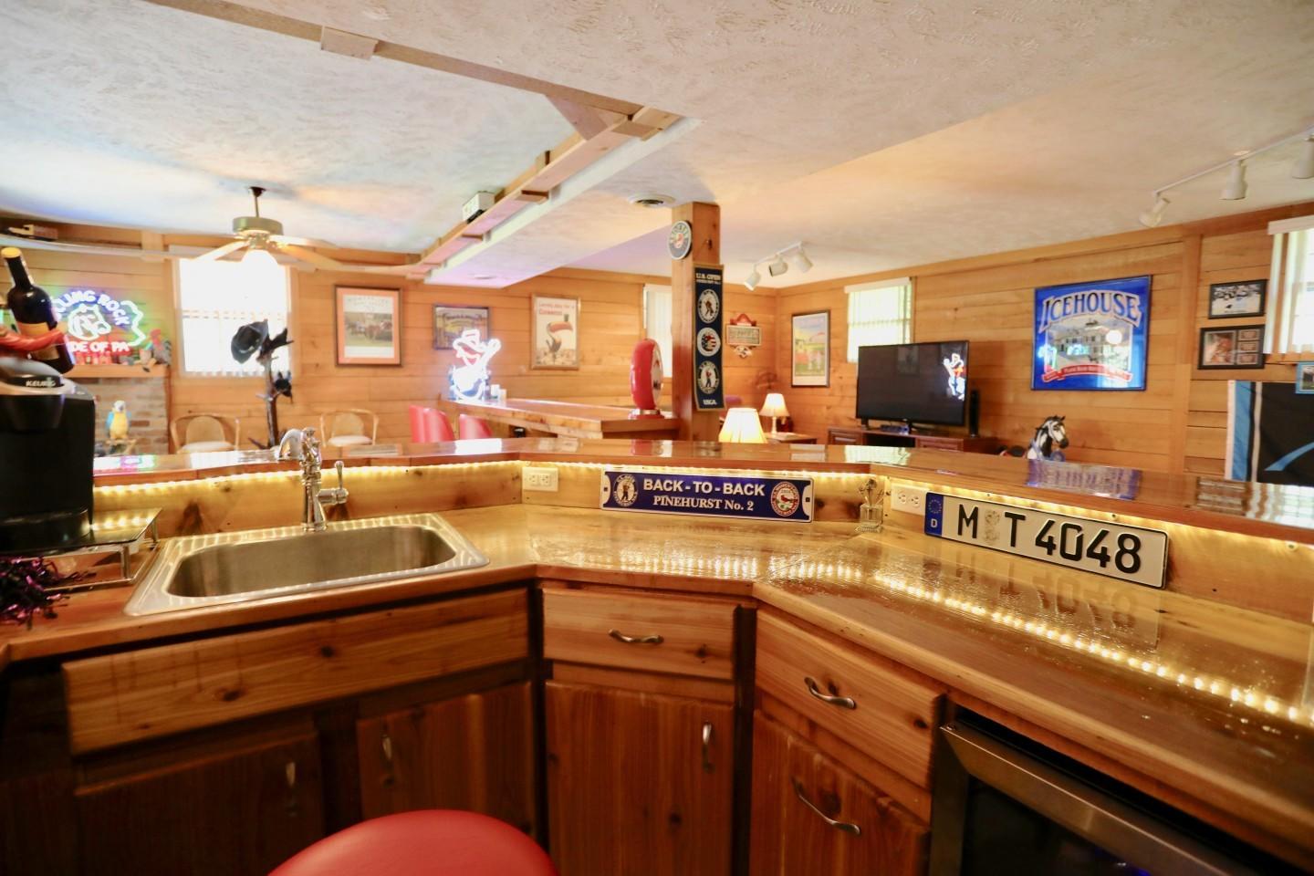 170 Boiling Spring Circle Southern Pines, NC 28387 - Photo 30 of 46 Custom basement bar made from cedar with updated electric, plumbing 2015 (full size sink, under counter fridge, microwave)