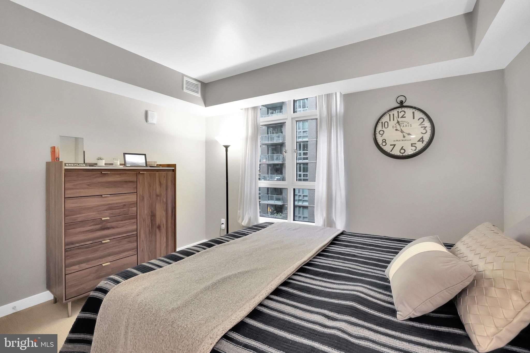 1025 First Street Southeast, Unit 602 Washington, DC 20003 - Photo 20 of 49 a bedroom with a bed and a chandelier