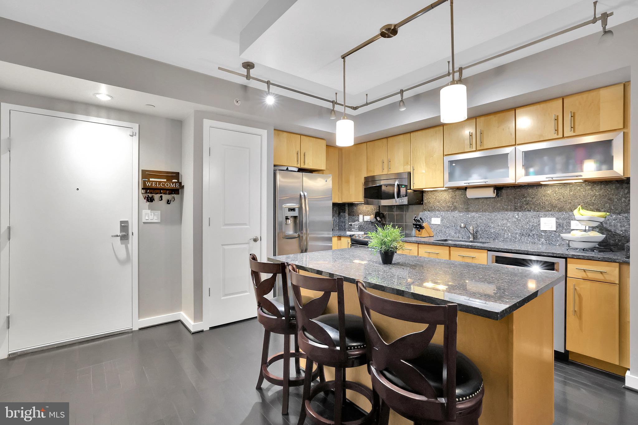 1025 First Street Southeast, Unit 602 Washington, DC 20003 - Photo 5 of 49 a kitchen with stainless steel appliances granite countertop a sink a stove and chairs