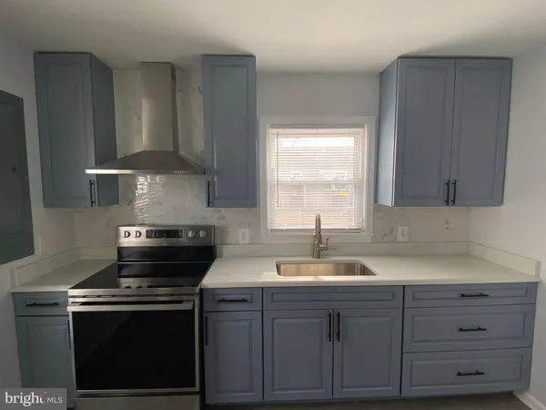 a kitchen with granite countertop a sink stove and cabinets