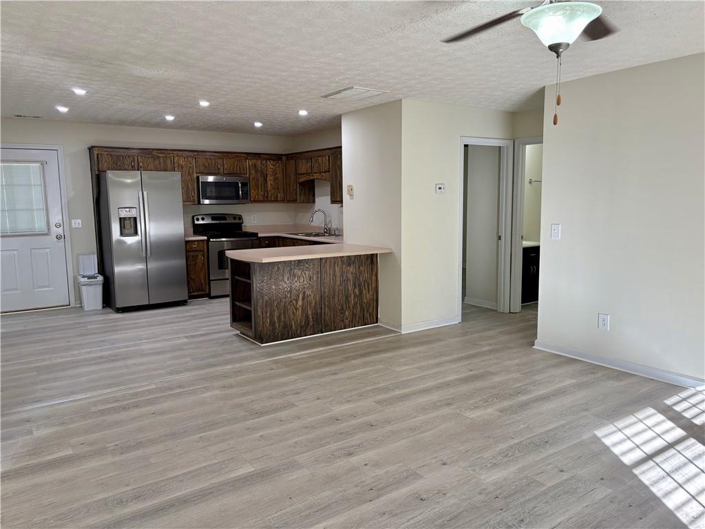 208 Maple Street Dawsonville, GA 30534 - Photo 4 of 21 a view of kitchen with stainless steel appliances granite countertop a stove top oven a refrigerator and a microwave