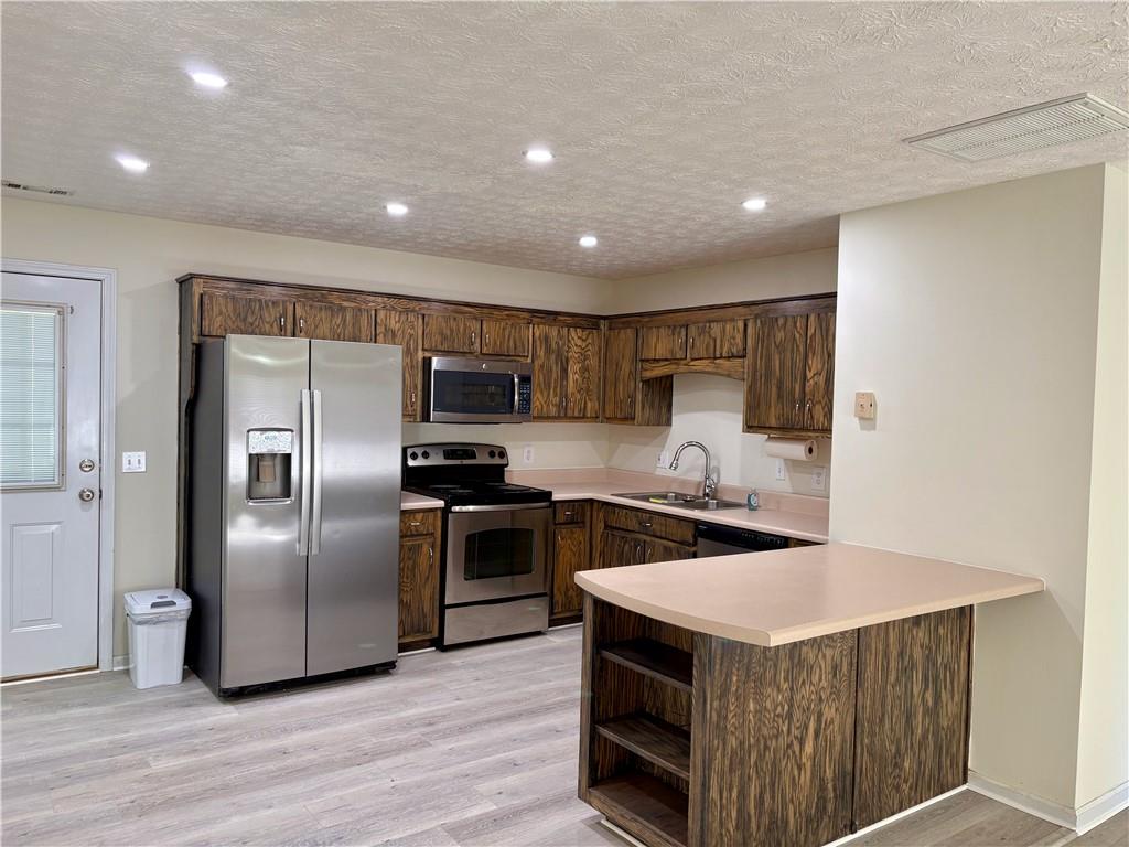 208 Maple Street Dawsonville, GA 30534 - Photo 5 of 21 a kitchen with stainless steel appliances granite countertop a sink a stove a refrigerator a washer dryer and white cabinets