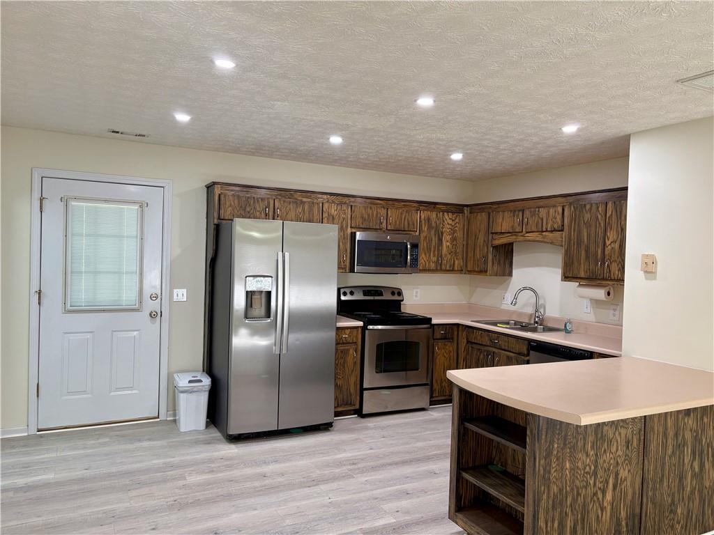 208 Maple Street Dawsonville, GA 30534 - Photo 8 of 21 a kitchen with stainless steel appliances granite countertop a sink a stove a refrigerator and a microwave