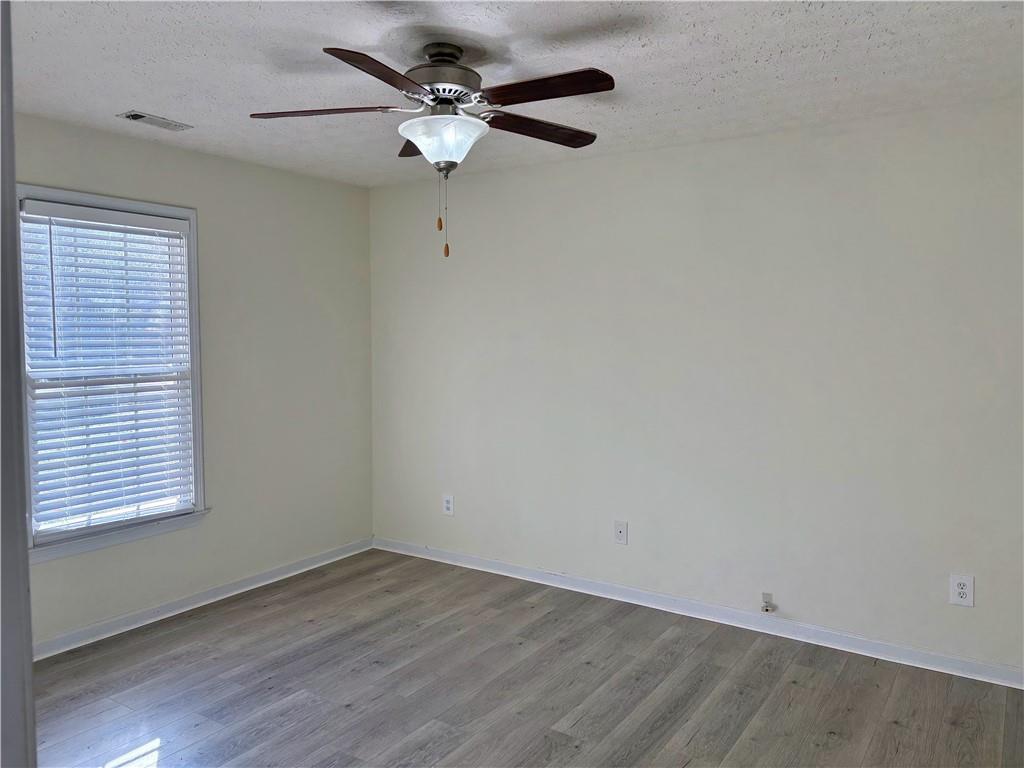 208 Maple Street Dawsonville, GA 30534 - Photo 9 of 21 an empty room with wooden floor fan and windows