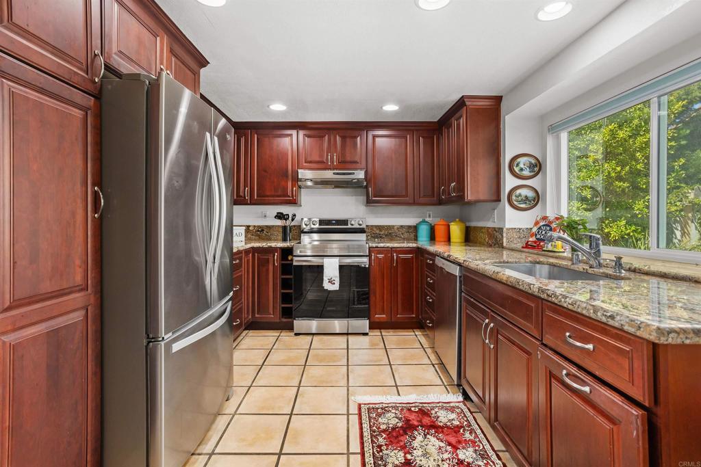 1991 Paseo Del Rey Vista, CA 92084 - Photo 15 of 42 a kitchen with stainless steel appliances granite countertop a refrigerator a sink a stove a microwave and island