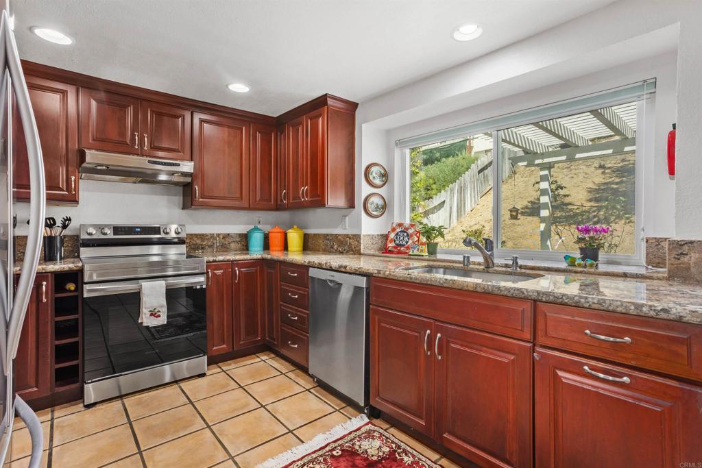 1991 Paseo Del Rey Vista, CA 92084 - Photo 16 of 42 a kitchen with stainless steel appliances granite countertop a stove a sink dishwasher and a microwave oven with cabinets