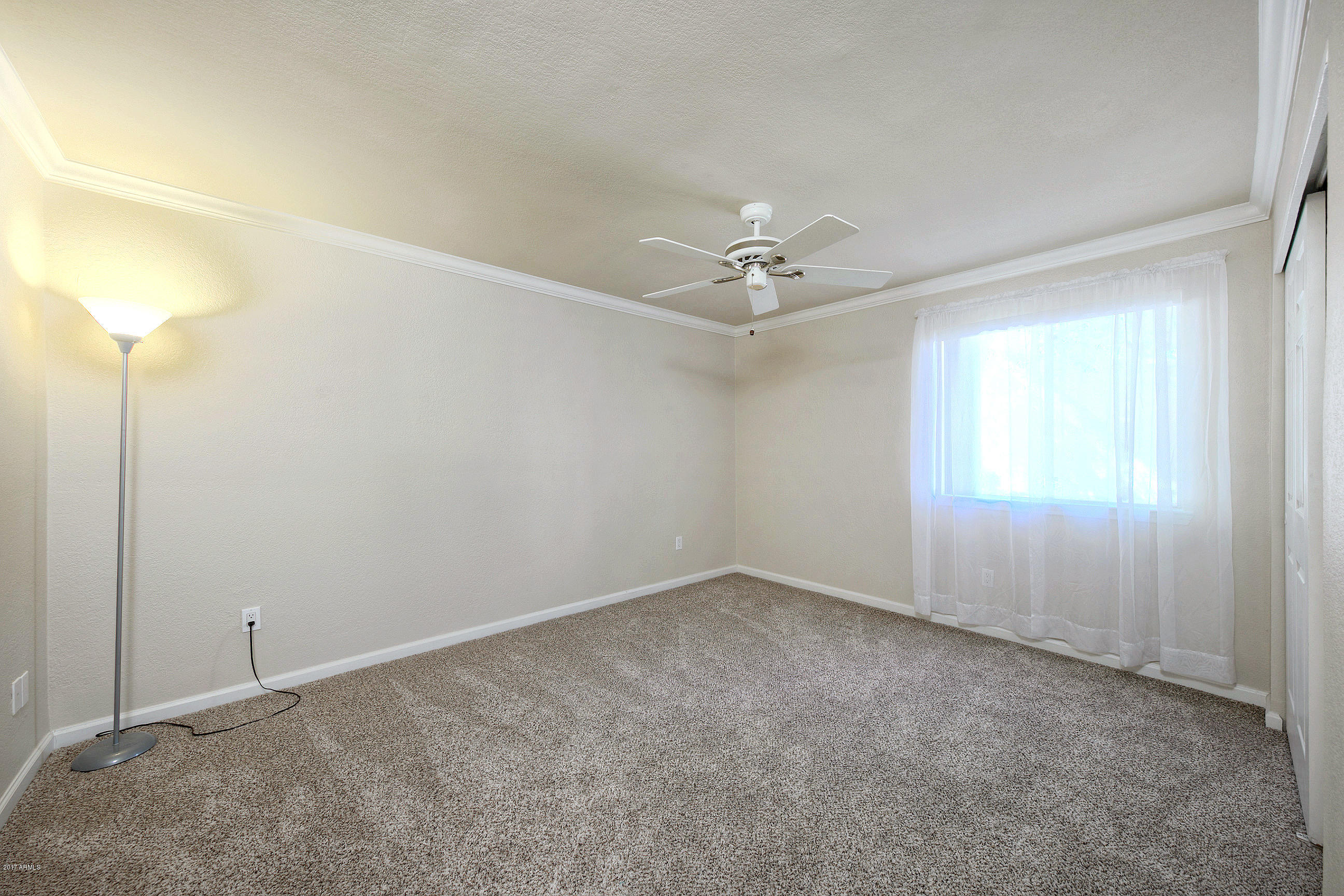 8256 East Arabian Trail, Unit 134 Scottsdale, AZ 85258 - Photo 14 of 24 an empty room with a fan & a window