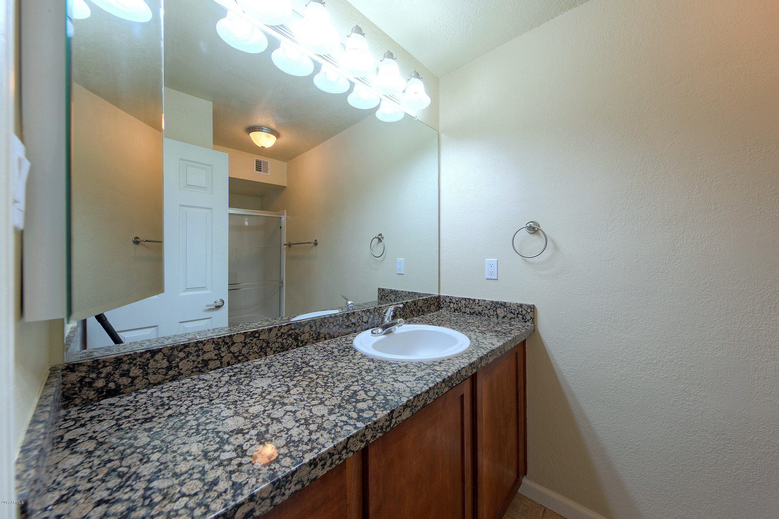8256 East Arabian Trail, Unit 134 Scottsdale, AZ 85258 - Photo 17 of 24 a bathroom with a granite countertop sink and a mirror