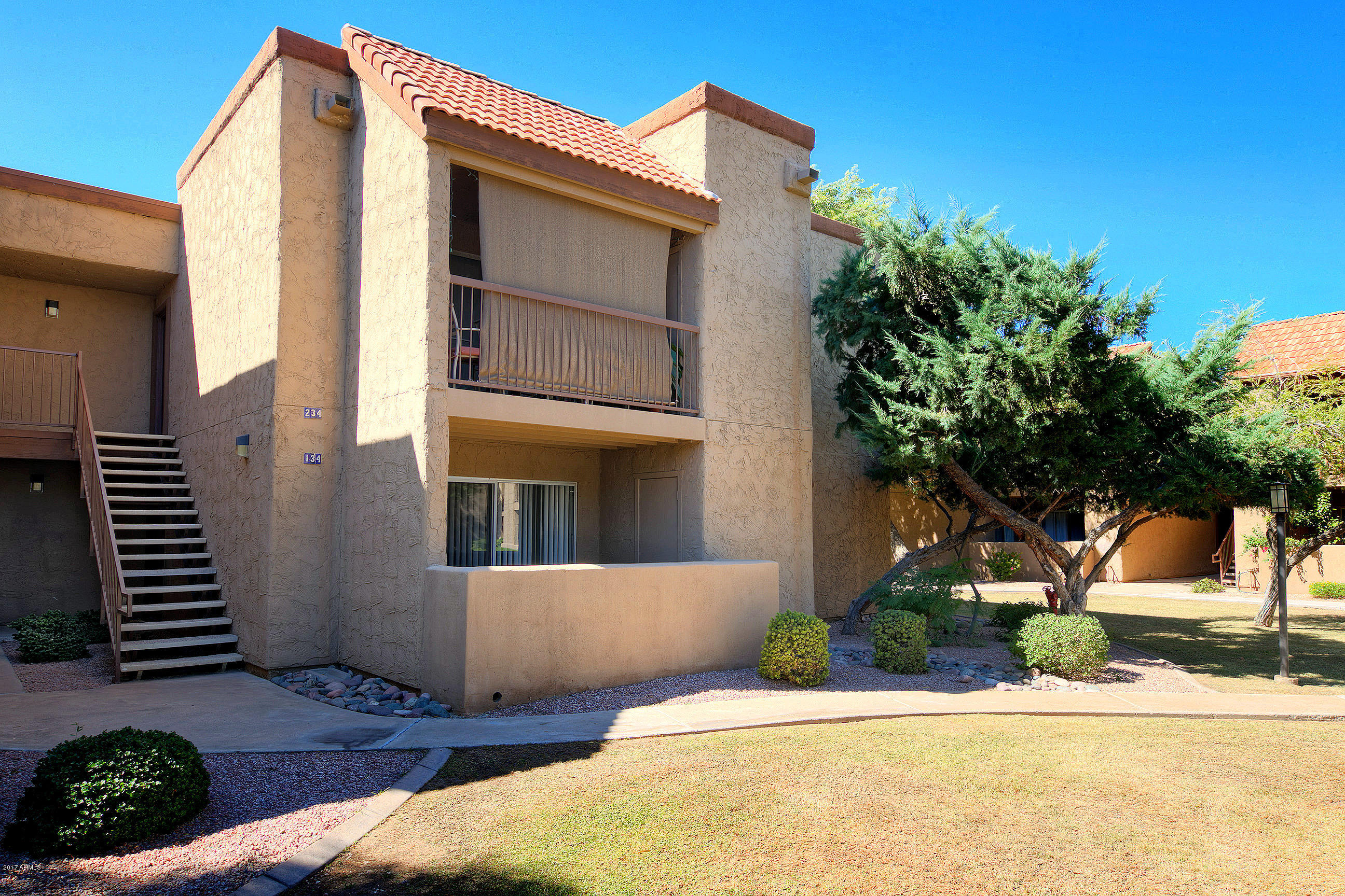 8256 East Arabian Trail, Unit 134 Scottsdale, AZ 85258 - Photo 2 of 24 a front view of a house with a yard