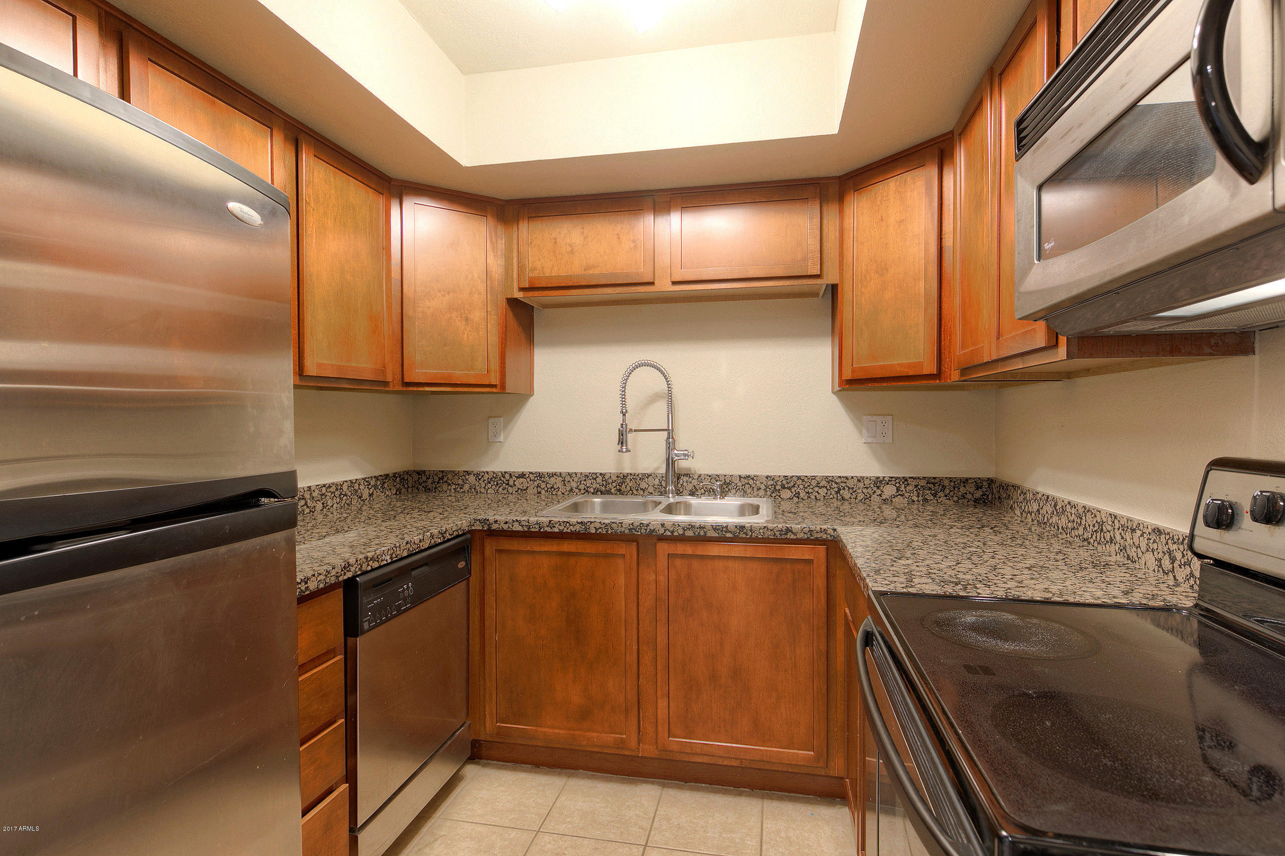 8256 East Arabian Trail, Unit 134 Scottsdale, AZ 85258 - Photo 9 of 24 a kitchen with granite countertop stainless steel appliances and sink