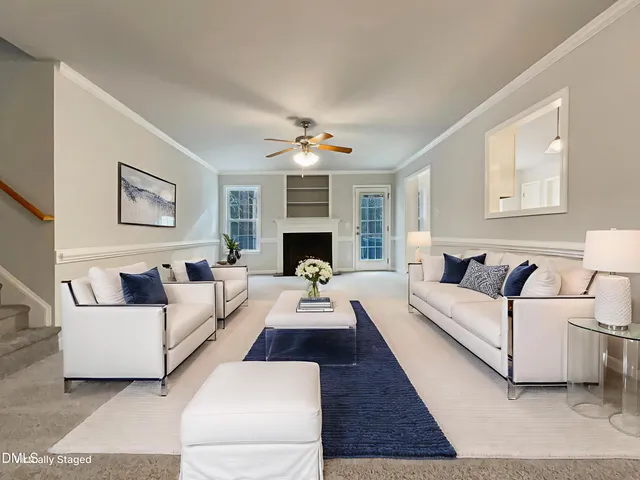 a living room with furniture a fireplace and a large window