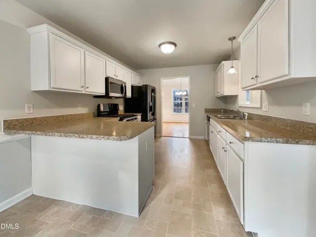 a large kitchen with cabinets stainless steel appliances and a counter space