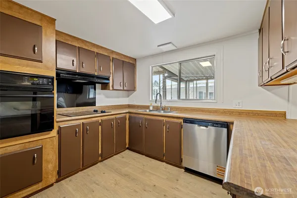 a kitchen with granite countertop a sink stainless steel appliances and cabinets