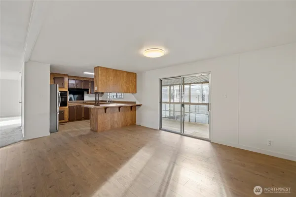 a large kitchen with stainless steel appliances granite countertop a stove a sink and a refrigerator with white cabinets