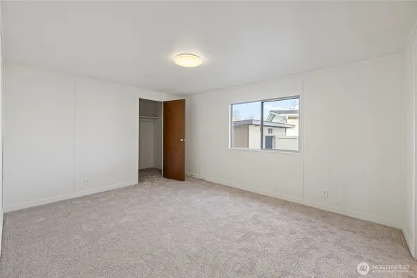 an empty room with windows and closet