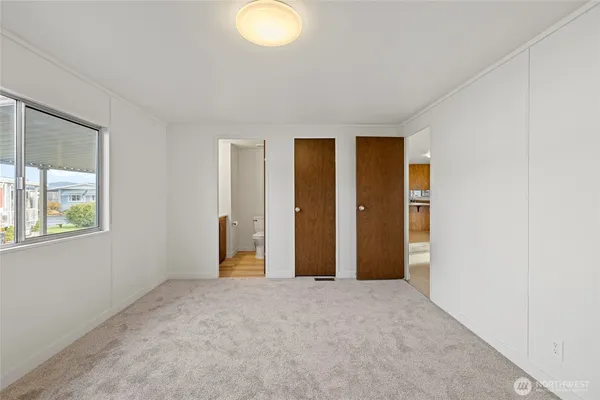 an empty room with windows and closet