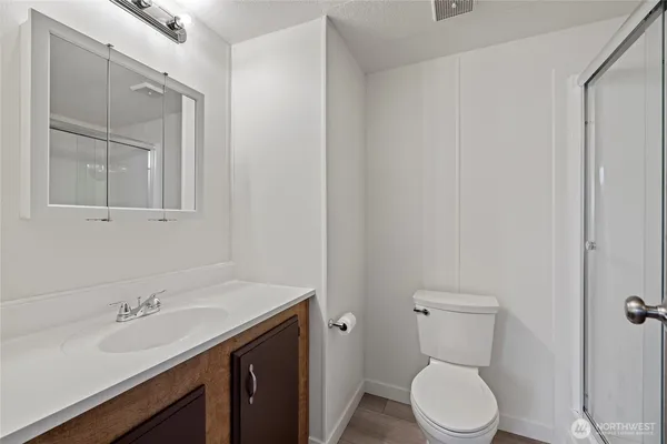 a bathroom with a toilet a sink and mirror