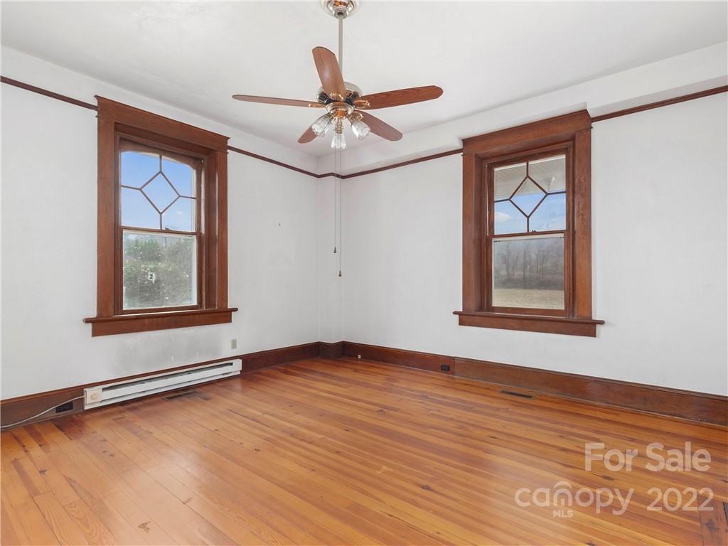 5593 Old Clyde Road Clyde, NC 28721 - Photo 9 of 35 an empty room with wooden floor fan and windows