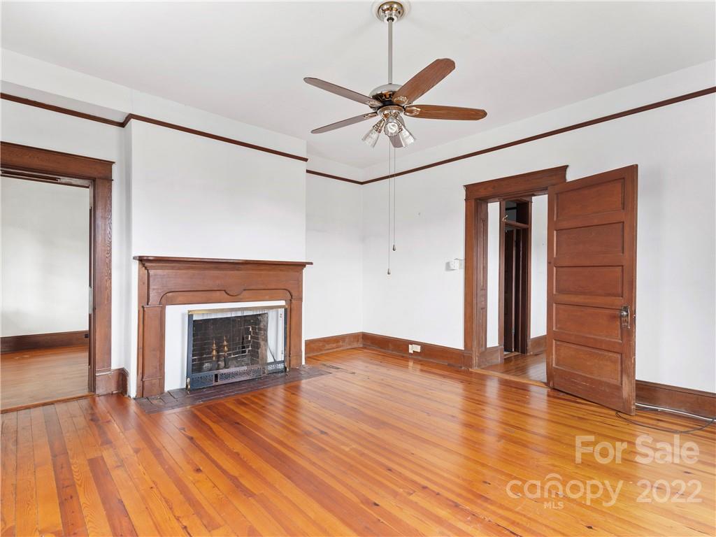 5593 Old Clyde Road Clyde, NC 28721 - Photo 10 of 35 a view of empty room with wooden floor and fireplace