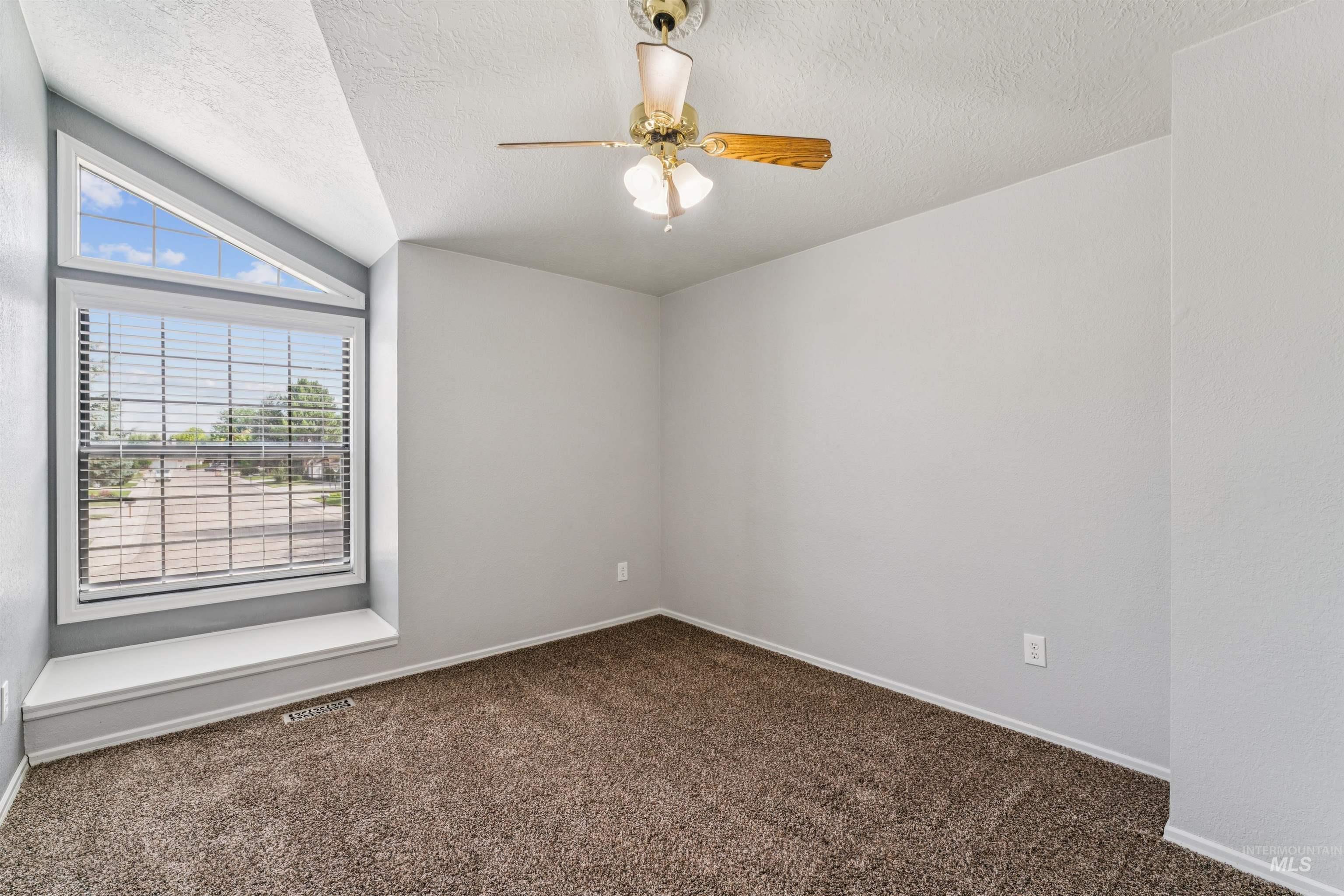 9831 West Ripley Street Boise, ID 83704 - Photo 27 of 47 Carpeted room featuring a built-in vanity with mirror and overhead lighting, a window with blinds, a ceiling fan, and a sliding door closet