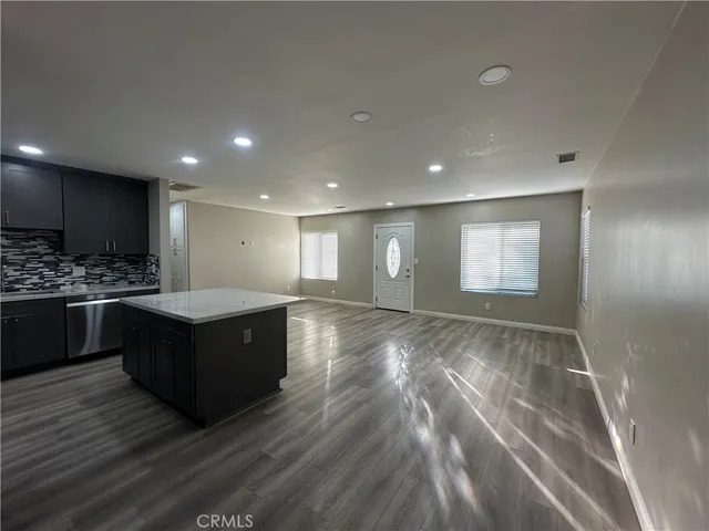 a large kitchen with stainless steel appliances granite countertop a large counter top a stove and a sink